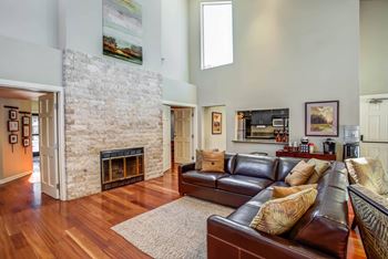 a living room with leather furniture and a stone fireplace  at Valley Plaza Villages, Pleasanton, California